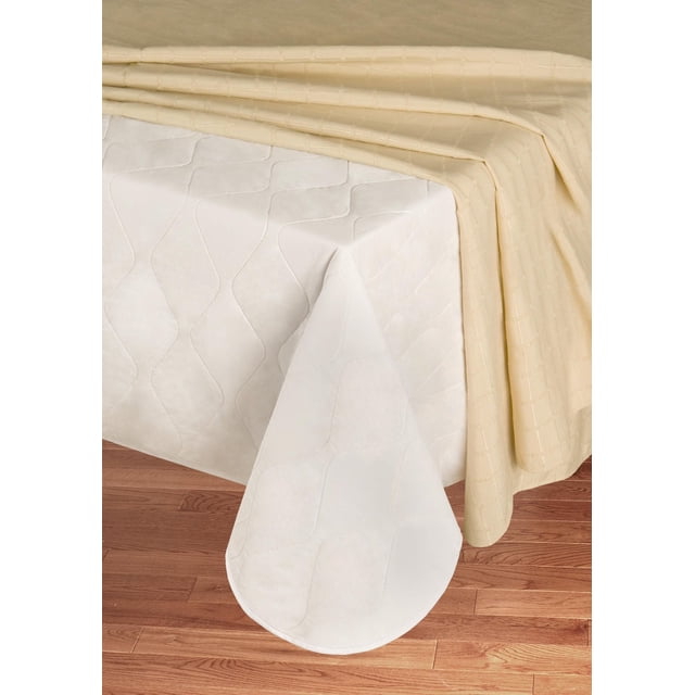 Mainstays Quilted Table Pad with white quilted plastic side facing up on a wooden table, partially covered by a beige quilted tablecloth, protecting the surface from spills and scratches and easy to clean with a damp cloth.
