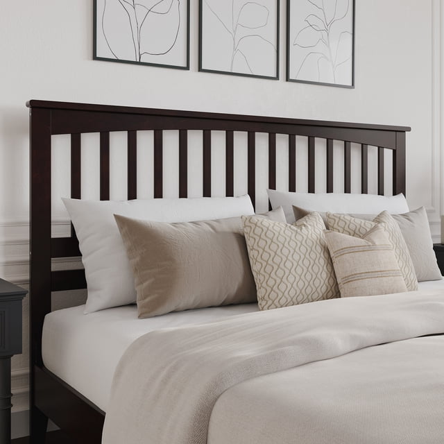 Tête de Lit en Bois Mission Très Grand Couleur Espresso Présentant un design Mission Classique avec Lattes Verticales et Moulure en Couronne. Fabriquée en Bois Franc Massif durable, Elle Est Présentée Attachée à un Cadre de Lit avec une Literie Neutre et des Coussins Décoratifs. la Finition Espresso Complète le Cadre Élégant de la Chambre avec un art Mural Encadré en Arrière-Plan.