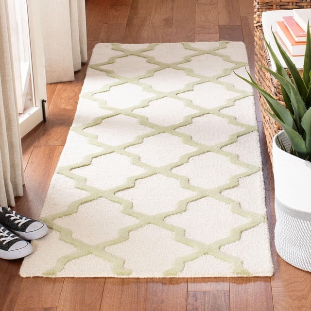 Safavieh Cambridge Tapis Géométrique Liam pour Aire Orientée vers l'Avant sur Plancher de Bois Franc, Présentant une base Crème avec Motif de Treillis Géométrique Vert Pâle, Laine Tuftée à la Main avec Poil Pelucheux Coupé et en Boucle, Placé Près d'Un Panier en Osier avec des Livres et une Plante en Pot, Convient à la Déco Moderne de la Maison Ou du Bureau.