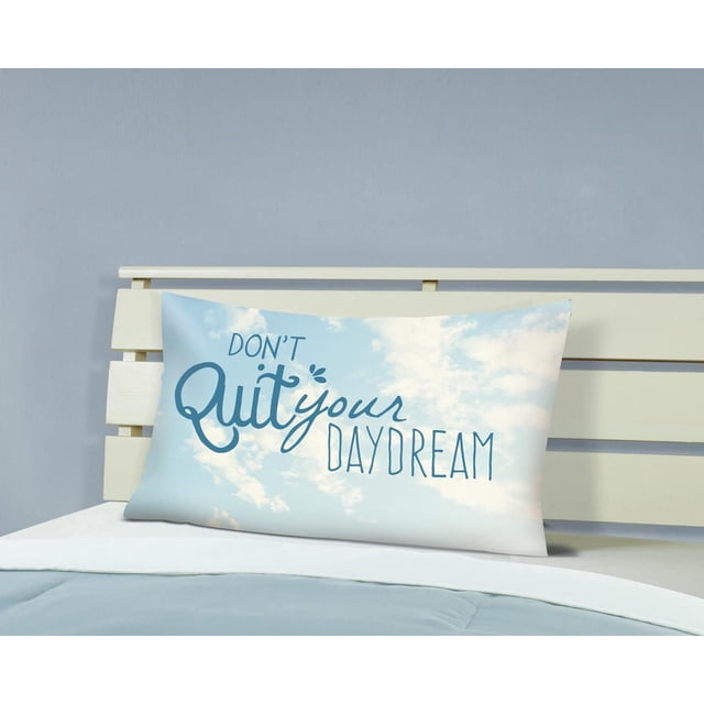 Mainstays Kids Taie d'Oreiller Imprimée Mesurant 20 par 30 Pouces avec un Motif de Ciel Bleu Pâle et de Nuages Blancs, Comprenant la phrase « Ne Quitte Pas Ton Rêve Éveillé » en Lettrage Bleu, Affichée sur un Cadre de Lit en Bois Blanc dans la Chambre d'Un Enfant.