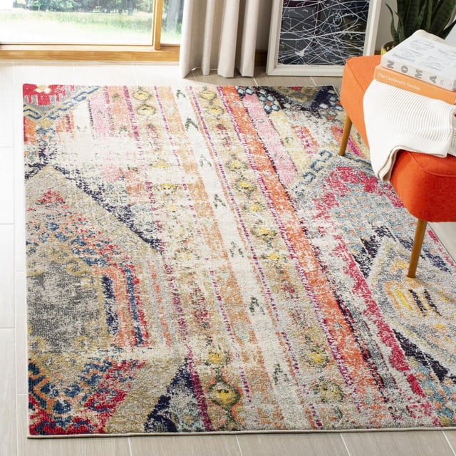 Safavieh Monaco Risto Abstract Area Rug with a power-loomed polypropylene construction, displaying a vibrant abstract pattern in red, blue, yellow, and beige tones, placed on light wood flooring near an orange chair and window with beige curtains, ideal for adding Bohemian-chic style to home interiors.