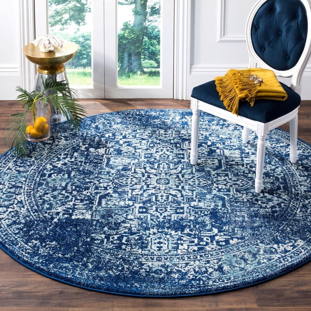 Safavieh Evoke Trena Tapis Traditionnel pour Aire, Rond avec un Motif floral Délavé Bleu et Blanc, Fait de Fils de Frise en Polypropylène Tissés Mécaniquement Durables pour Douceur et Entretien Facile, Exposé sur un Plancher de Bois Franc à Côté d'Une Chaise en Bois Blanche avec Siège en Velours Bleu Marine et Jeté Moutarde, Près d'Un vase en Verre Tenant des Citrons et de la Verdure par une Fenêtre Lumineuse.