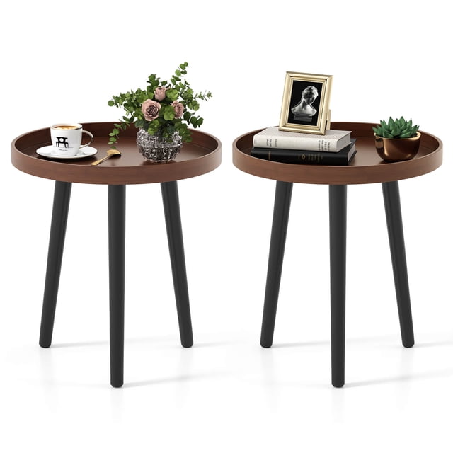 Costway 2 PCS Round Side Table Sofa Coffee End Accent Table Nightstand Home Furniture featuring two round tables with brown MDF panel trays and black triangular bamboo legs. Each table has a lipped edge for safety and stability, and a compact design for versatile use in living rooms, bedrooms, or offices. The tables are shown with decorative items like a coffee cup, books, and plants.