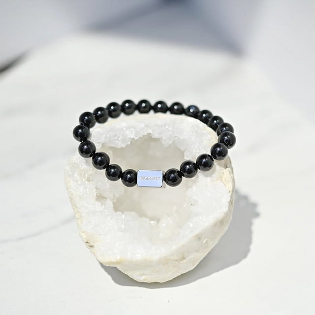 Bracelet Worthy en Onyx Noir Comprenant 21 Perles d'Onyx Noires de 8 mm Enfilées sur un Cordon Extensible durable. le Bracelet Comprend une Barre en Acier Inoxydable de Qualité Médicale Gravée de « Worthy » Qui Résiste au Ternissement et à la Décoloration. Affiché sur une Géode de Cristal Blanche, Ce Bracelet en Cristal pour Femme Est Conçu pour la Mise à la Terre, la protection et le Contrôle de Soi. Taille Unique Convient à la Plupart (18-18,5 cm) et Est Livré avec une Carte mantra et un Sac à Poussière