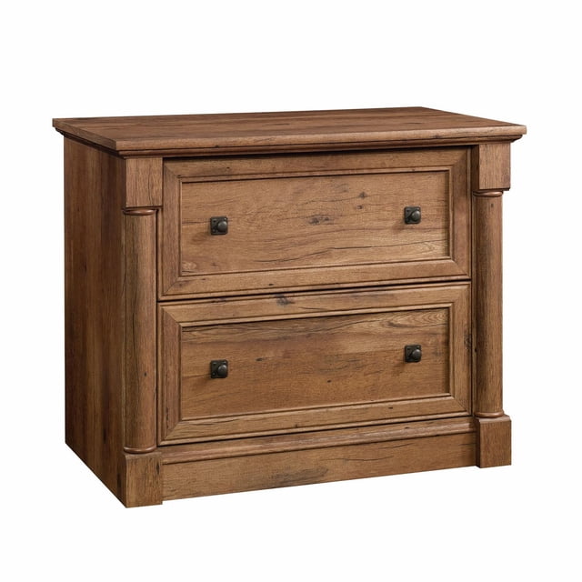 Sauder Palladia® Lateral File in a vintage oak finish, featuring two lateral file cabinet drawers with full extension slides for letter, legal, or European size hanging files. The design includes framed panel doors, pilasters, and contoured bases, offering a classic and versatile look suitable for office or home use. Patented interlocking safety mechanism allows only one drawer to open at a time.