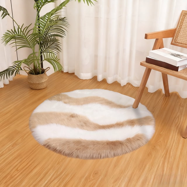 Uuiauoio Circle Rugs for Bedroom, a round faux fur rug in coffee and white tones, measuring 23.62x23.62 inches. The rug is displayed in a cozy room setting with wooden flooring, a wicker chair, and a potted plant nearby. Its soft polyester material and velvety texture make it suitable for kids' decor, living rooms, bedrooms, or dorms as a decorative and comfortable small area rug.