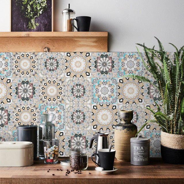 Lucoss 24pcs 6-inch peel and stick vinyl backsplash tiles featuring intricate, colorful patterns in a kitchen setting. These self-adhesive, waterproof, and removable tile decals are ideal for decorating walls, kitchens, bathrooms, and furniture. Made from environmentally friendly vinyl, they are easy to apply and remove without leaving residue. The image shows the tiles arranged as a backsplash behind a wooden countertop with various kitchen items, including a coffee maker, jars, and a potted plant.