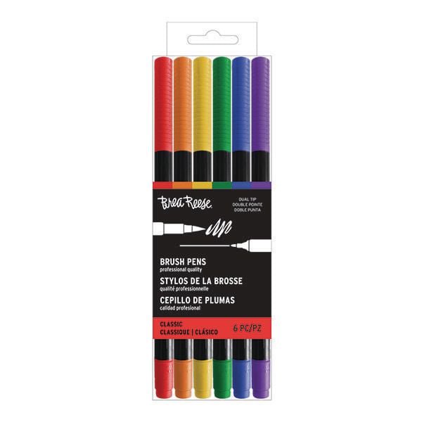 Momenta Inc Brea Reese Dual Tip Brush Pen 6pc - Primary set of six dual tip brush pens in red, orange, yellow, green, blue, and purple with black barrels, designed for art and drawing projects, packaged in clear plastic with branded label.