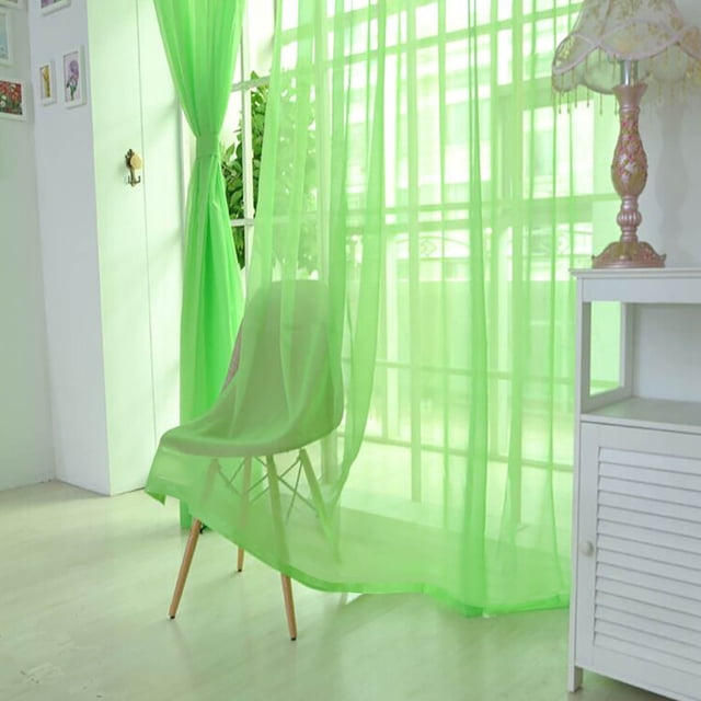 Green sheer glass window curtain measuring 80x200 cm, made of 100% polyester Gorgan fabric with a rod pocket design. The curtain features a modern voile material that gently filters sunlight, creating a soft and elegant ambiance. Displayed in a bright room with natural light, the curtain drapes over a chair and complements the surrounding decor.