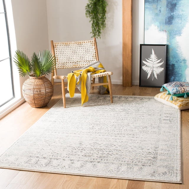 SAFAVIEH Tulum Flint Distressed Southwestern Area Rug, 6'7" x 6'7" square ivory and grey geometric design on light hardwood floor, complemented by a woven wooden chair with yellow and grey throws, a wicker planter with palm leaves, and decorative cushions and framed botanical art, suitable for enhancing rustic boho living spaces.