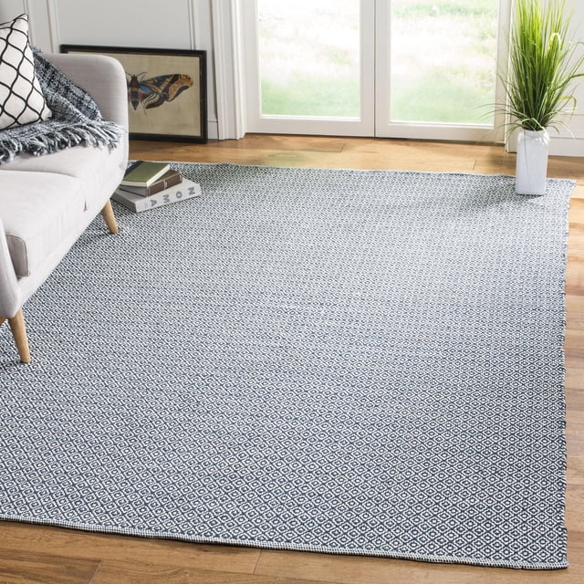 SAFAVIEH Montauk Tapis en Coton Géométrique Audra avec texture en Coton Tissé à Plat et Petit Motif Losange Bleu Marine Blanc, Posé sur Plancher de Bois Franc dans un Salon avec sofa beige, Imprimé Papillon Encadré et Grande Plante Verte Près des Portes en Verre, Idéal pour les Intérieurs Côtiers Ou Contemporains.