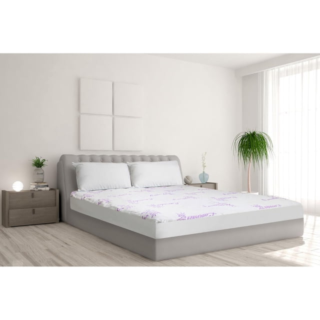 Safdie & Co. Protège-Matelas Tricoté Lavande Traité T Blanc Ajusté sur un Lit Grand avec une Tête de Lit Capitonnée Grise Rembourrée dans une Chambre Lumineuse. le Protège-Matelas Blanc Présente un Léger Imprimé Lavande et Est Imperméable, Hypoallergénique et Silencieux. la Pièce Comprend Deux Tables de Nuit en Bois avec des Articles Décoratifs, une Plante en Pot Près d'Une Grande Fenêtre avec des Rideaux Transparents, et un Plancher de Bois Clair. Convient aux Personnes Souffrant d'Allergie et d'Asthme.