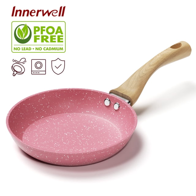 Innerwell 8 Inch Pink Nonstick Frying Pan Skillet with a speckled granitic coating and ergonomic wood-grained bakelite handle. The pan features a toxin-free, ultra non-stick surface for easy cooking and cleaning, and a durable, fast-heating three-layer aluminum base. Suitable for various stoves, including induction, gas, electric, and ceramic. The lightweight handle remains cool during cooking, ensuring safe and comfortable use.