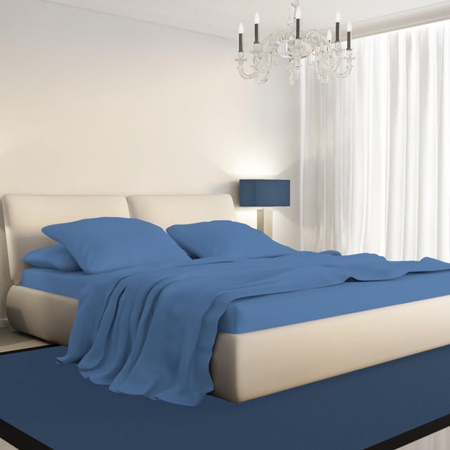 Johnson Home 450 Thread Count Bamboo Bed Sheet Set in blue on a beige upholstered bed with padded headboard, including fitted sheet, flat sheet, and two pillowcases. The bamboo fabric is breathable, moisture-wicking, hypoallergenic, and wrinkle-resistant. The bedroom features white curtains, a blue lampshade on a bedside table, and a glass chandelier, emphasizing eco-friendly, temperature-regulating bedding ideal for year-round comfort.