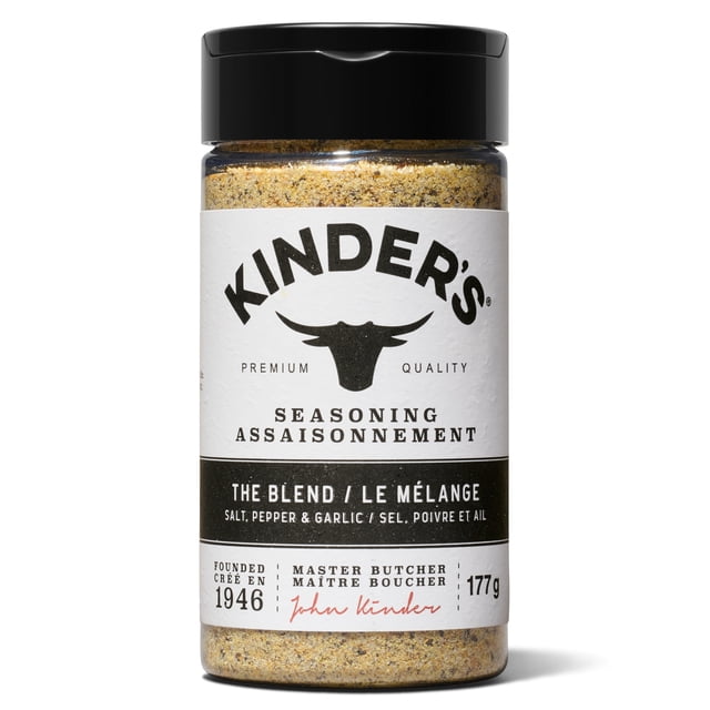 Kinder's The Blend Seasoning Spice 177g in a clear plastic bottle with a black flip-top lid, containing a coarse blend of salt, cracked pepper, and garlic. The white label features the Kinder's logo with a bull head silhouette, bilingual English and French text, and notes the seasoning's 1946 master butcher heritage. Suitable for enhancing chicken, beef, fish, pork, and vegetables.
