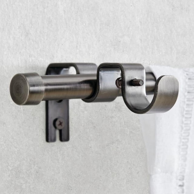 Better Homes & Gardens 5/8" plated pewter adjustable add on curtain rod kit, 32"-120", close-up side view of a steel rod with cylindrical end cap and double rod pocket bracket in pewter finish mounted on a light grey wall, designed for layering curtains and includes mounting hardware.