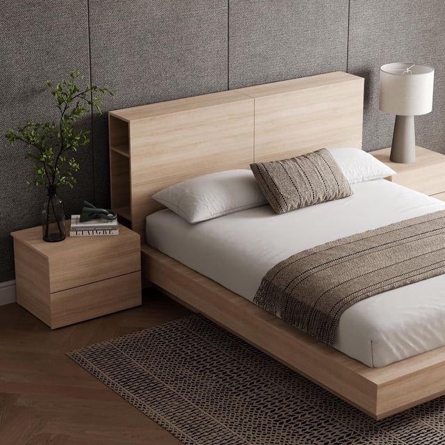Nexera Marconi 4-Piece Bedroom Set with queen-size platform bed in light wood featuring a minimalist headboard with built-in storage shelves, paired with two matching 2-drawer nightstands. The bed is styled with white linens, a beige textured throw and pillow, set on a patterned rug against a neutral textured wall with a modern lamp on one nightstand.