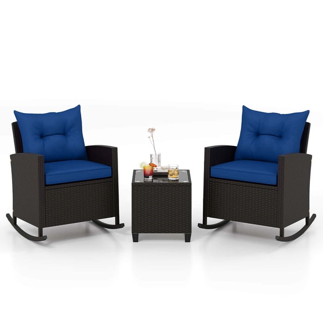 Costway 3 PCS Patio Wicker Rocking Set with Tempered Glass Table & Soft Cushions Outdoor Navy. This small space patio set includes two mix brown PE rattan rocking chairs with navy cushions and a square coffee table with a tempered glass top. The chairs feature ergonomic backrests, curved armrests, and non-slip stoppers for stable rocking. The table is designed with suction cups to secure the glass top, making it ideal for outdoor spaces like patios, gardens, or poolside areas.