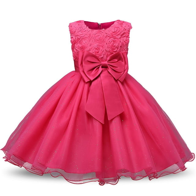 AAMILIFE Girl Princess Flower Dress Tutu Wedding Birthday Party Child Dress Kids Costume in a vibrant pink color. This sleeveless, knee-length A-line tutu dress features a round neckline, a large decorative bow at the waist, and a floral lace bodice. The multi-layered tulle skirt is adorned with subtle glitter accents, creating a sparkling effect. Designed for special occasions such as weddings, birthday parties, and beauty pageants, this dress is made from soft lace tulle with a cotton lining for comfort. The back includes a hidden zipper for easy wear.