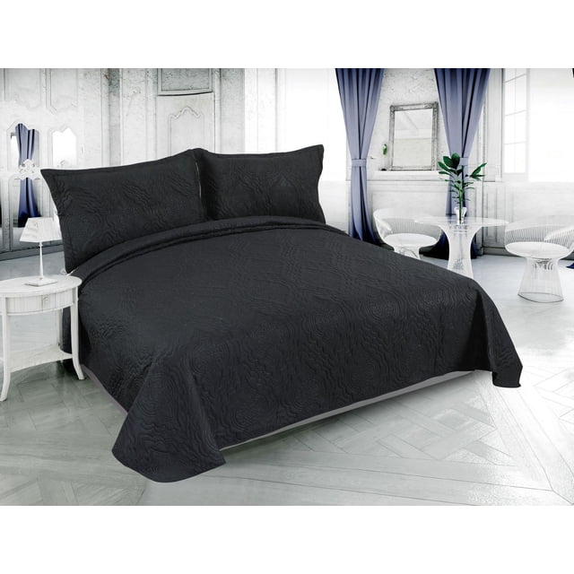 Marina Decoration Solid Embossed Pinsonic Coverlet Bedspread Bedding Ultra Soft Summer Quilt Set with Shams in black color, displayed on a bed in a bright room with white walls and blue curtains. The quilt features a solid embossed floral pattern with breathable brushed microfiber and polyester fill, designed for lightweight, all-season comfort. Includes matching pillow shams with the same embossed design, suitable for summer use and reversible for versatile bedding.