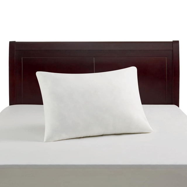Mainstays Cotton Pillow Protector on a white pillow on a white mattress with a dark wood headboard, featuring breathable 200-thread count cotton fabric with SILVADUR antimicrobial protection to prevent stains and odour, machine washable for easy maintenance.