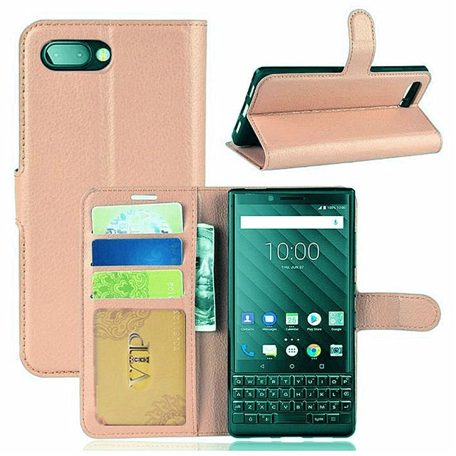 Blackberry KeyTwo Lite Key2 Lite Wallet Case by Phonesmart, featuring a leather magnetic card slot wallet folio flip case cover. The case includes multiple credit card slots, a pocket for bills, and a magnetic clasp for secure closure. It is made of premium soft synthetic leather with a TPU inner case for shock absorption and drop protection. The design allows the case to convert into a media stand. Shown in a light pink color with a Blackberry Key2 Lite phone inside, displaying its functionality.
