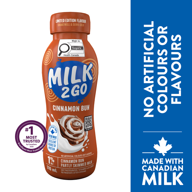 Milk2Go 1% M.F. Cinnamon Bun Limited Edition Partly Skimmed Milk in a 310 ml brown plastic bottle featuring cinnamon bun and milk splash graphics, Health Canada sugar warning, and Canadian milk source badge, with no artificial colours or flavours.