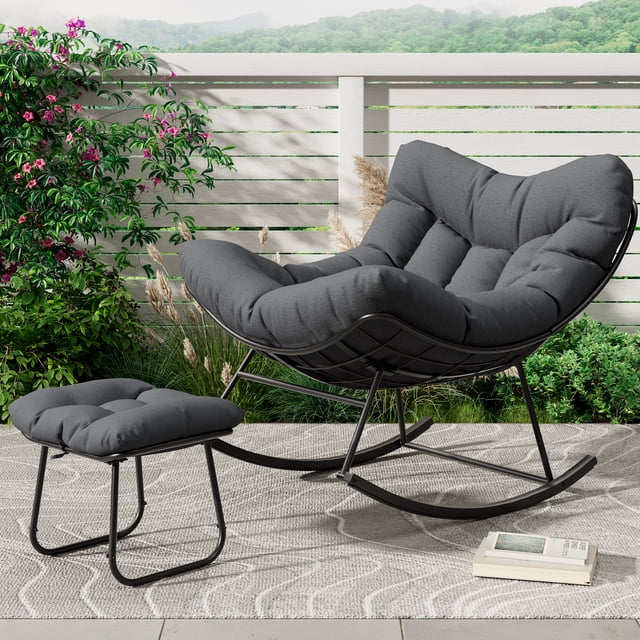 Oversized Papasan Rocking Chair with Footrest, 350Lbs Capacity Indoor/Outdoor Rocker, metal frame with handwoven UV-resistant PE wicker egg silhouette, deep curved seat with 5-inch high-density waterproof cushion and matching ottoman/footrest, adjustable patio lounge rocker on a sunlit deck; often used as a cozy reading nook or extra seating.