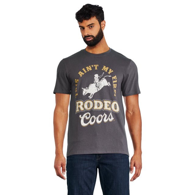Coors T-shirt de Rodéo pour Homme en Tricot jersey Gris avec Imprimé Graphique à l'Avant d'Un Cavalier de Taureau de Rodéo et le Texte « This ain't My First Rodéo Coors », Comprenant une Encolure Ras du Cou, des Manches Courtes, des Épaules Légèrement Tombantes et un Ourlet Droit, Assorti à des jeans Bleu Foncé, Idéal pour les Sorties Décontractées Ou la Détente à la Maison.
