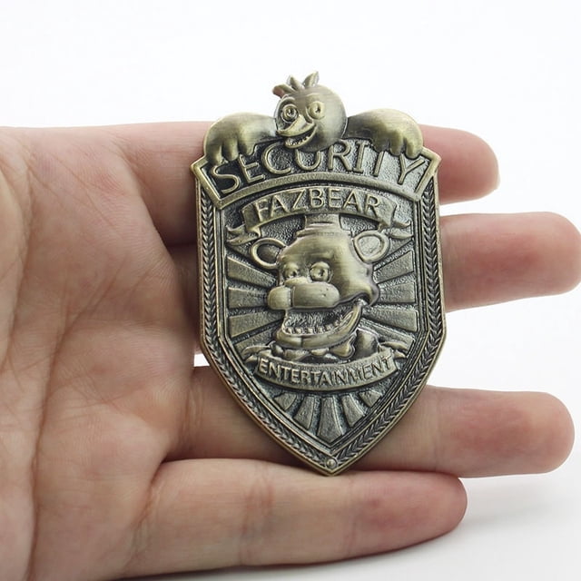 Alloy Five Nights at Freddy's FNAF Fazbear Security Badge Pin with a bronze finish, showcasing the Fazbear Entertainment logo and character in detailed engravings. The pin measures 6.5 cm in length and is displayed in hand for size reference. Ideal for collectors or fans of the franchise.