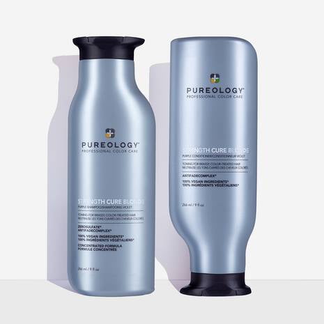 Pureology Strength Cure Blonde Shampoo and Conditioner Duo, 9 oz bottles, designed to tone and neutralize brassiness in blonde and lightened hair. The set includes a shampoo and conditioner in sleek, light blue bottles with black and inverted caps, featuring a ZeroSulfate and 100% vegan formula. Provides hair strength, softness, and colour protection with the patented Antifade Complex.
