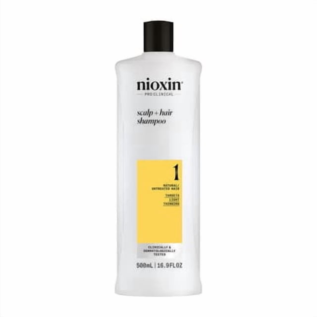 Nioxin Shampooing pour Cuir Chevelu + Cheveux - System 1, Bouteille de 500 ml pour Cheveux Naturels avec Éclaircissement Léger. la Bouteille Blanche avec Capuchon Noir Présente une Étiquette Jaune Indiquant System 1. Idéale pour le Traitement du Cuir Chevelu, Elle Est Enrichie en niacinamide et en Biotine pour Renforcer les Cheveux et Réduire la Casse.