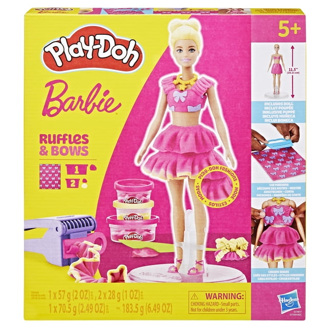 Play-Doh Barbie Ruffles and Bows Doll Set with an 11.5-inch Barbie doll on a clear stand wearing a pink Play-Doh ruffled dress and bows. Includes three cans of Play-Doh compound, ruffle maker tool with two attachments, cutter, hair mold, shoes, and accessories for creative doll fashion and hairstyle design, suitable for kids 5 and up.