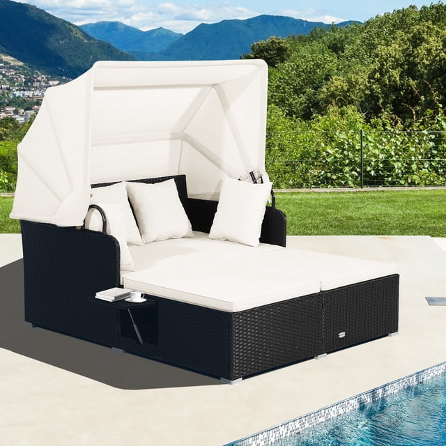 Costway Chaise Longue en Rotin pour Patio Daybed avec Auvent Rétractable Blanc Cassé, Cadre en Osier Noir et tables d'Appoint, Idéale pour la Détente en Plein Air au Bord de la Piscine Ou du Patio, Entourée de Verdure.