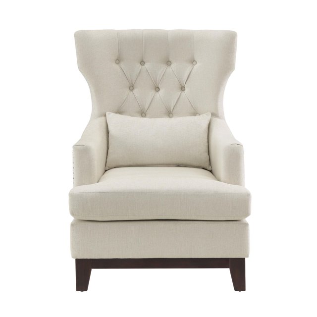 Topline Home Furnishings Accent Chair in beige neutral textured fabric with wing-backed silhouette, button-tufted back, silver-toned nailhead trim, and exposed espresso-finished wooden legs. Includes matching lumbar pillow and reversible seat cushions with removable covers.