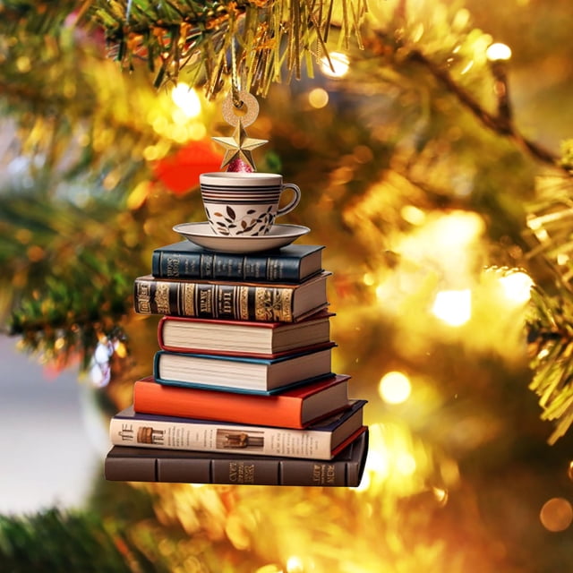 RKSTN Christmas Decorations 3pc Tree Car Pendant Acrylic Decoration Holiday Home Decorations. A close-up view of a Christmas tree ornament featuring a stack of books in various colours, topped with a teacup and saucer, and a golden star. The ornament hangs from a tree branch with warm holiday lights in the background, creating a festive ambiance.