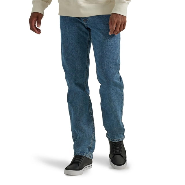 Wrangler Men's Five Star Relaxed Fit jeans in blue denim with a straight leg and classic five-pocket design, made with stretch fabric that sits at the natural waist, shown on a model wearing black sneakers and a beige sweatshirt, ideal for casual and social occasions.