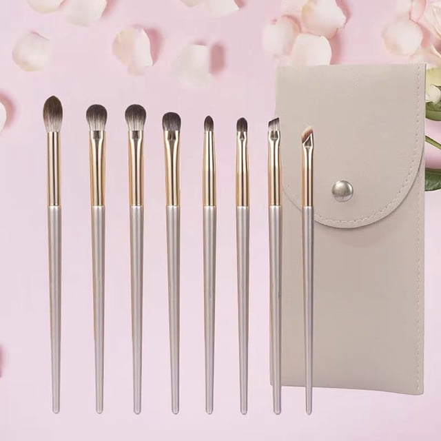 EGNMCR Makeup Brushes 8-Piece Makeup Brushes Set with soft bristles, ideal for eye makeup application. Includes various brush types for blending and detail work, along with a beige storage pouch for organization. Displayed on a pink background with flower petals.