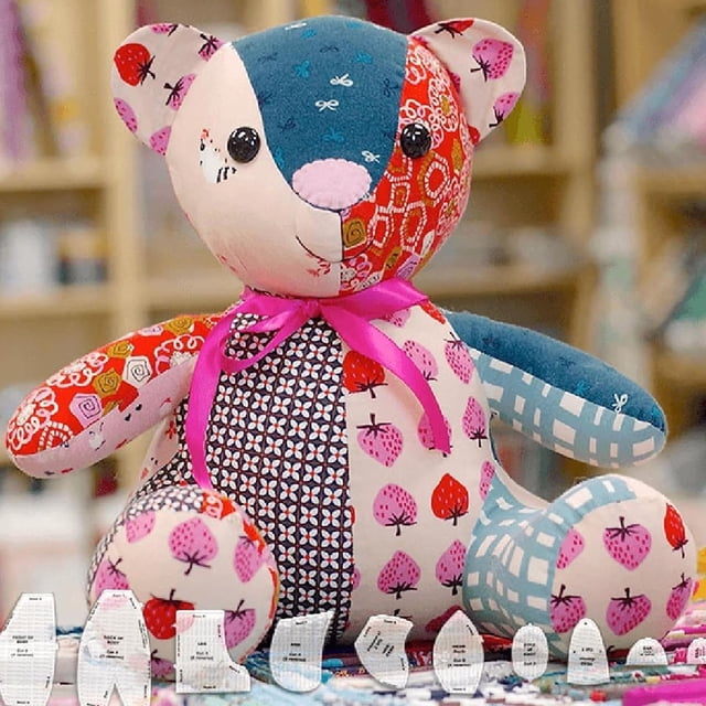 LAICAIW Memory Bear Template Ruler Set shown with a completed handmade memory bear crafted from vibrant patterned fabric. The bear features a pink ribbon, button eyes, and a patchwork design made from old clothing. Acrylic templates for DIY sewing patterns are arranged in the foreground, highlighting the tools included in the kit. Perfect for crafting keepsake bears and preserving cherished memories.