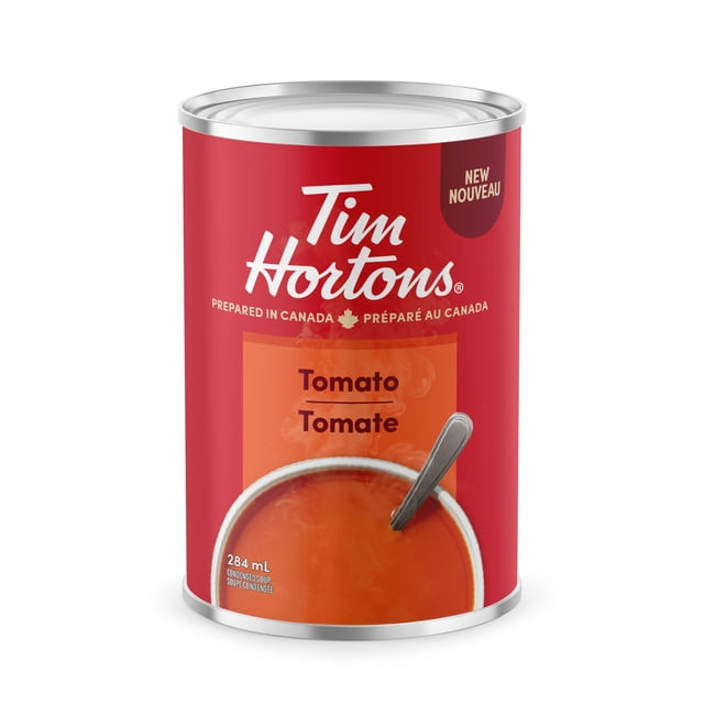 TIM HORTONS TOMATO CONDENSED SOUP 284 mL can with a red label featuring the Tim Hortons logo and bilingual 'Tomato Tomate' text. The metal can shows steaming tomato soup with a spoon, prepared in Canada, vegetarian, with 25% lower sugar and no artificial colours or flavours.