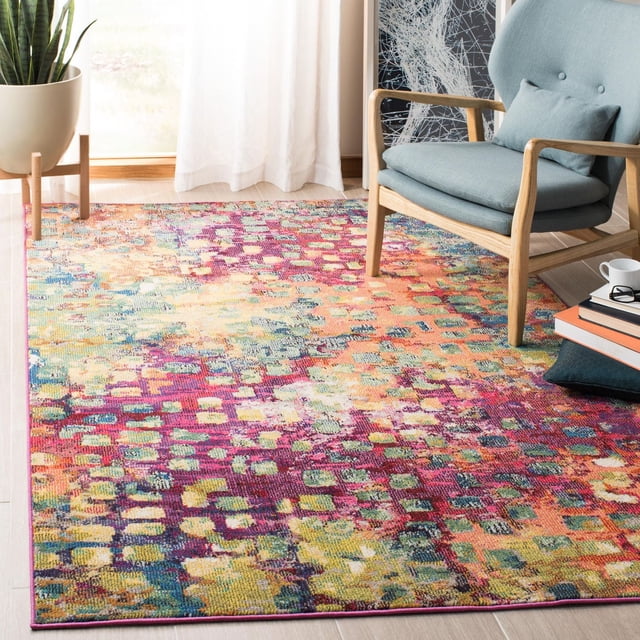 SAFAVIEH Madison Candelario Abstract Polka Dots Area Rug with a vibrant abstract polka dot pattern in magenta, yellow, green, and blue tones, power loomed for durability, displayed in a bright room with a light blue wooden armchair, a potted plant, and stacked books, suitable for adding a modern accent to contemporary home decor.