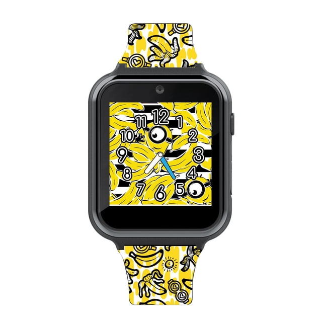 Minions Touch Screen Interactive Watch with Camera with a black rectangular touchscreen displaying an analog clock face featuring Minions and bananas on a yellow and black striped background. The yellow watch band is decorated with matching Minions and banana designs. It includes a front camera and side button, suitable for children aged 6 and up with functions like games, calculator, and pedometer.