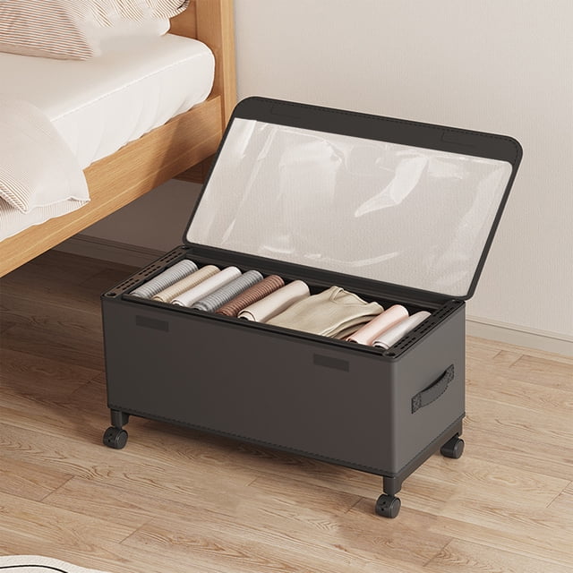 TopLLC under bed storage with wheels, featuring a black cloth material and a clear PVC lid for visibility. The storage container measures 22.4 x 11.8 x 11.4 inches and includes 360-degree rolling wheels for easy mobility. Shown in a bedroom setting, the container is partially open, revealing neatly folded clothes inside. Designed for multi-purpose use, it is ideal for storing shoes, clothes, books, or seasonal items under the bed. The sturdy metal frame and Oxford fabric construction ensure durability and efficient organization.