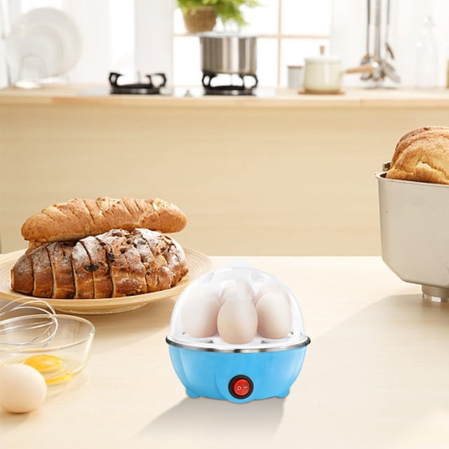 EGNMCR Multifunctional Eggs Cooker (Single Layer, American Standard) Egg boiler on a kitchen counter. The compact blue appliance with a transparent lid can steam up to seven eggs. It is surrounded by bread, a bowl with cracked eggs, and other kitchen items, showcasing its multifunctionality for steaming eggs, warming milk, and preparing complementary foods.