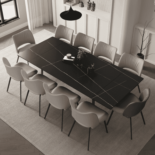 NessCarsti Modern Living Extendable Dining Table, 62.9"-94.4", featuring a black sintered stone tabletop with heat and scratch resistance. The table is fully extended, surrounded by 10 beige upholstered chairs in a modern dining room. Its durable stainless steel frame ensures stability, making it ideal for large gatherings and everyday use.