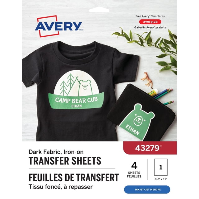 Avery Dark T-Shirt Transfers, 11" x 8 ½", for Inkjet Printers showing a black T-shirt with a green and white iron-on design of a bear, trees, and the text 'Camp Bear Cub Ethan', alongside a matching black pouch with the same bear design and name, placed on a light wood surface with green leaves and colored pencils, suitable for customizing dark cotton or cotton/poly fabrics.