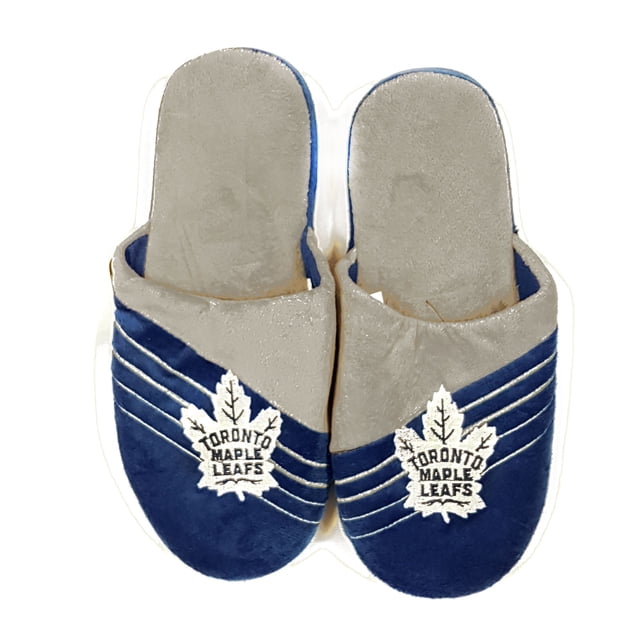 Maple Leafs de Toronto LNH Pantoufle pour Homme à Grand Logo par Forever Collectibles avec un Motif Peluche Bleu et Gris et des logos d'Équipe Brodés à l'Avant. Fabriquée avec une Semelle en Plastique Caoutchouc durable et une Tige en Acrylique Souple. sous Licence Officielle LNH, Ces Pantoufles Antidérapantes et Lavables, Idéales pour les fans de la Marchandise Maple Leafs de Toronto. Offertes en Plusieurs Tailles.