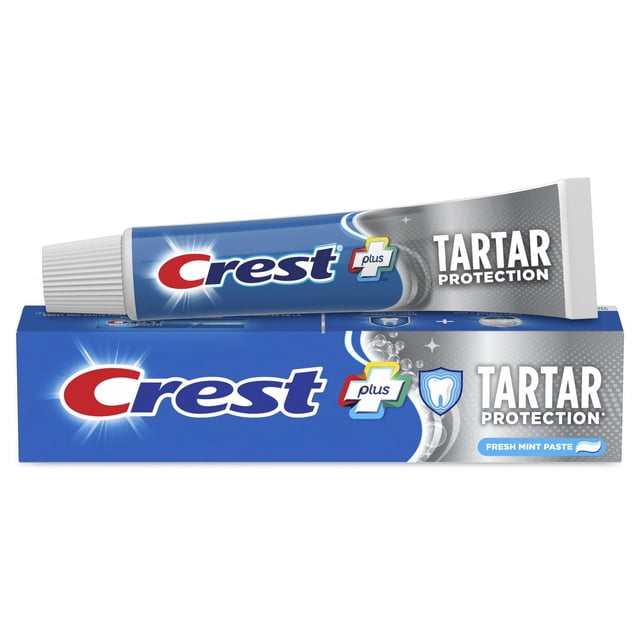 Crest Plus Tartar Protection Toothpaste, Regular Paste, featuring a blue and silver tube resting on its box. The packaging highlights tartar protection, cavity treatment, enamel strengthening, and fresh mint flavour for effective oral care.