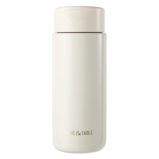 Thyme & Table Double Wall Insulated Stainless Steel Coffee Tumbler, 22oz travel mug in cream with a smooth matte finish, designed to keep drinks hot for 8 hours and cold for 12 hours, featuring a leak-proof lid and fitting most cup holders, also suitable for carrying cold beverages on the go.
