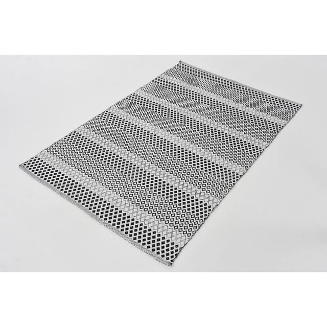Vista Area Rug with black and white geometric diamond stripes, handmade from natural fabrics with low pile height, designed for high-traffic areas in contemporary, bohemian, or transitional home styles, also suitable for entryways or kitchens.